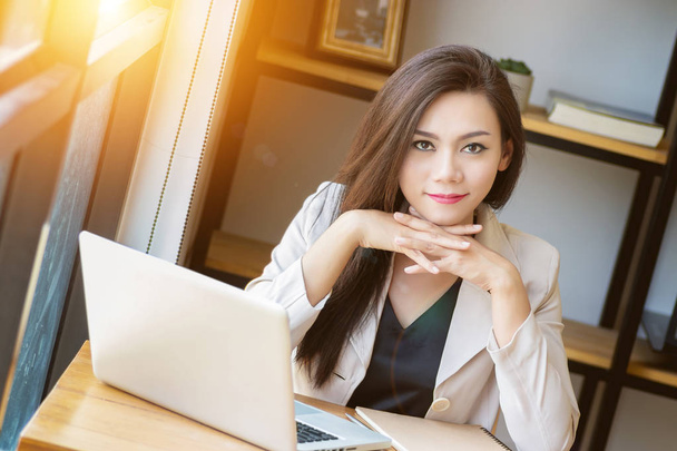 portrait of beautiful and confident Asian business woman in working age using computer laptop technology for manage job work, look at camera. businesswoman ,  girl power and International Women's Day - Foto, Bild