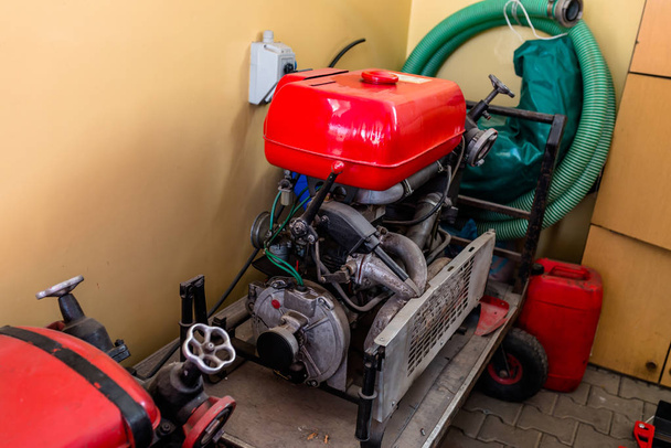 Przenośna pompa benzynową zamontowana na wózku do pobierania wody z zbiorników wodnych, wykorzystywanych przez strażaków. - Zdjęcie, obraz