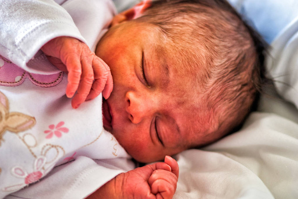 Το νεογέννητο μωρό κοιμάται τις πρώτες μέρες της ζωής. Χαριτωμένο μικρό νεογέννητο παιδί - Φωτογραφία, εικόνα