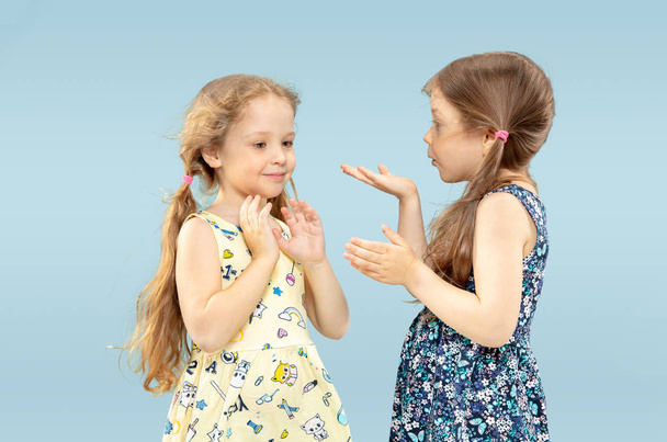 Beautiful emotional little girls isolated on blue background - Foto, imagen