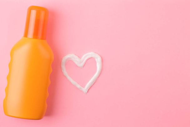 sunscreen remedy. various sunscreens and a cream heart against a bright pink background. Sun protection. Ultraviolet protection. Summer. top view. - Photo, Image