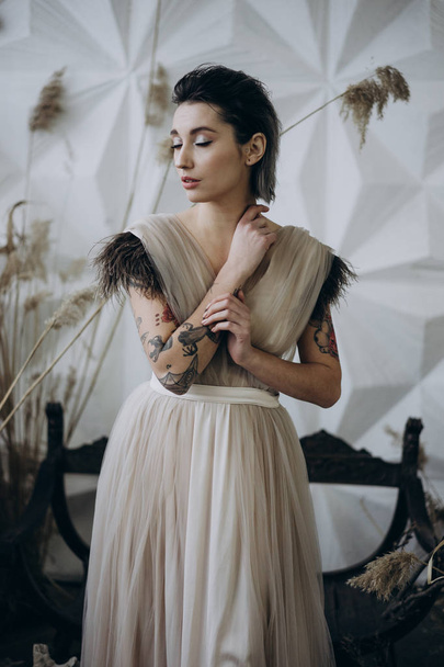 portrait of tattooed lady with closed eyes posing in the studio wearing dress  - Φωτογραφία, εικόνα