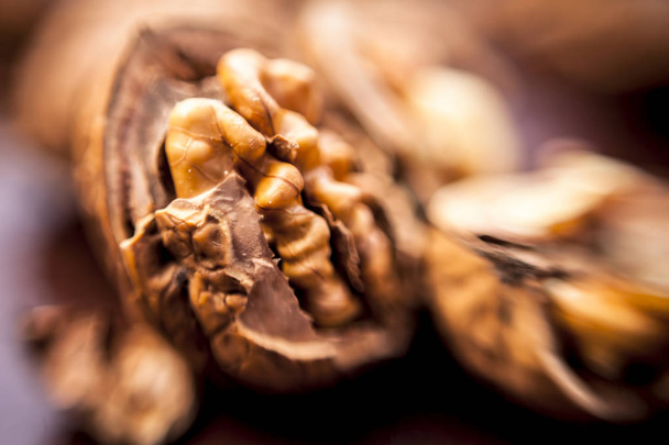 Macro shot of raw organic walnuts in sell on wooden surface. - Valokuva, kuva