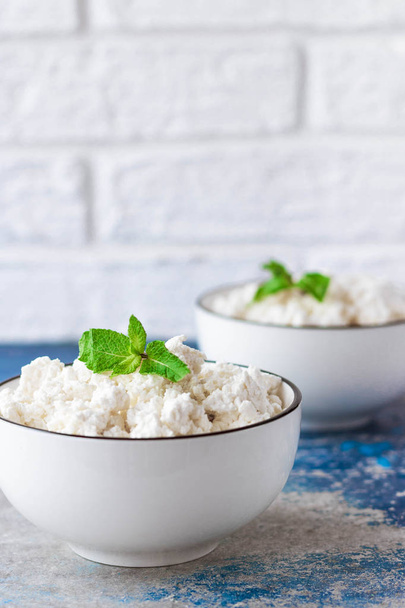 Cottage cheese with mint leaves on a light background in white bowl - Photo, Image