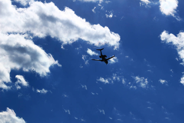 空に輝く太陽の下で飛ぶジェット旅客機 - 写真・画像