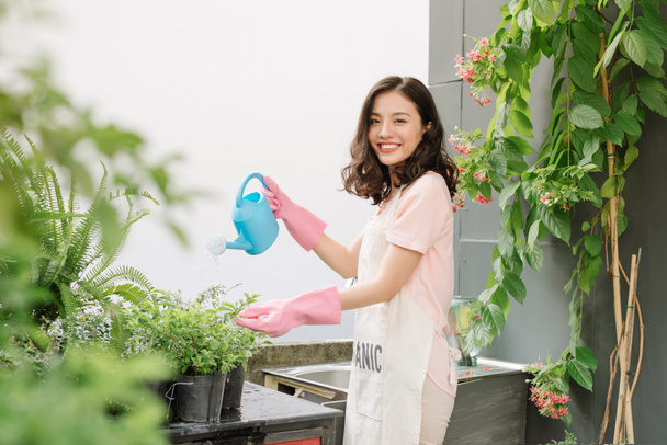 Asiatico ragazze blu irrigazione in giardino a terra
  - Foto, immagini