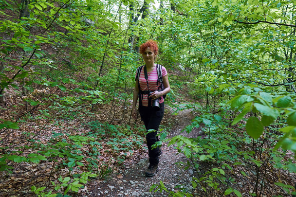Active woman on a hiking trail in forest - Photo, image