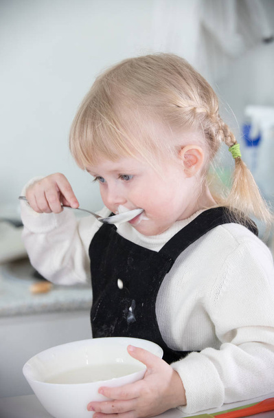 Een klein meisje dat een zure room eet - Foto, afbeelding