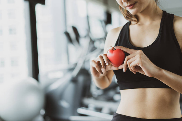 Здравоохранение Красное сердце спортивные женщины тренировки упражнения в тренажерном зале фитнес здоровый образ жизни с копией пространства слева
. - Фото, изображение