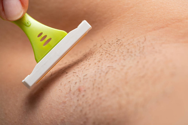 Hairy armpit, shaving with razor - Фото, изображение