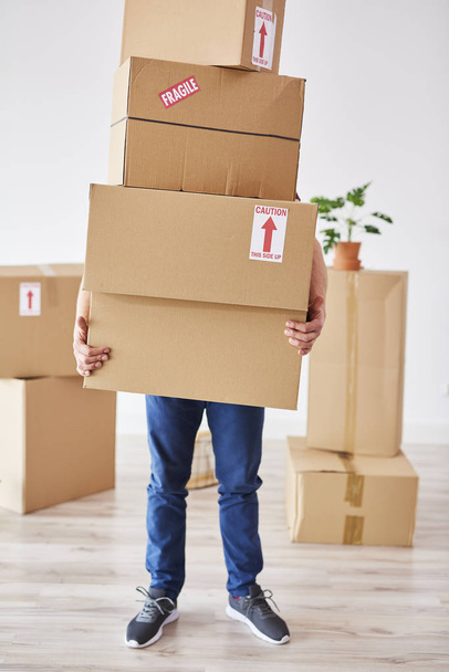 Man holding stack of boxes in front of his face  - Foto, Bild