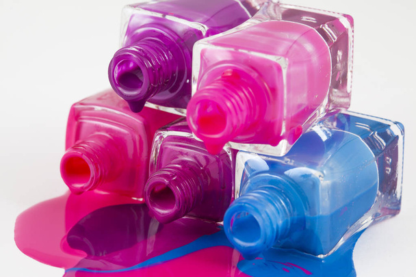 Botellas con esmalte de uñas derramado sobre fondo blanco - Foto, imagen