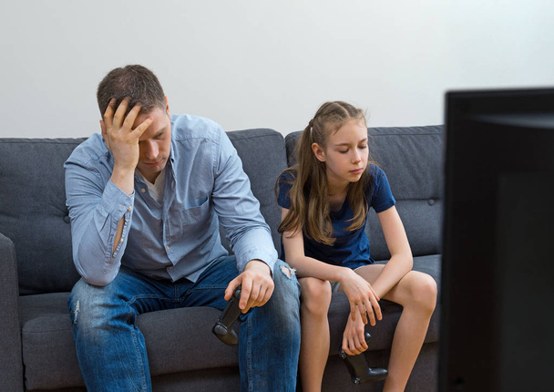 Upset father and daughter sitting on the sofa with gamepads. - Photo, Image