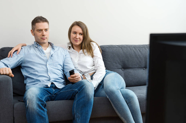 Man and woman watching TV at home. - 写真・画像