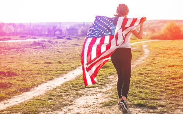 Women running in the field with American flag USA celebrate 4th of July - Photo, Image