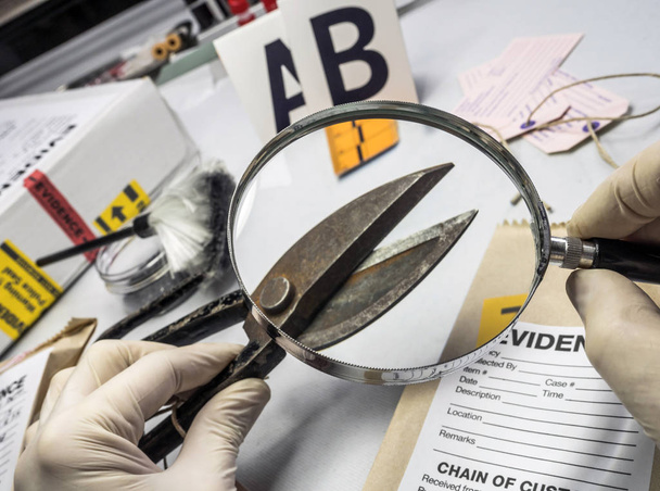 Экспертная полиция проводит экспертизу с помощью увеличительных стеклорежущих ножниц в лабораторном криминалистическом оборудовании, концептуальное изображение
 - Фото, изображение