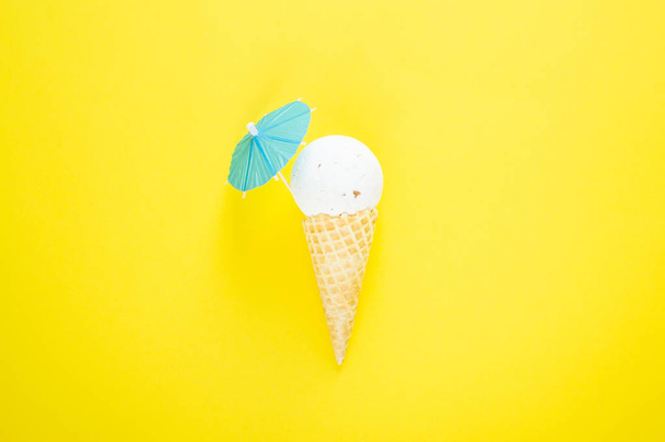 omposition of ice cream cone with white bath ball with beach umbrella. Bathroom cosmetic accessories. Flat Lay. Top View. Summer creative concept - Foto, Imagem