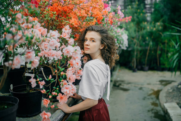 The young girl walks in a summer garden - Фото, изображение