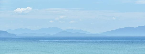 kék meleg táj háttér trópusi tenger hegyek sziluettek. A szöveg másolása szóközzel - Fotó, kép