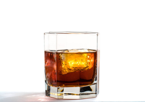 Fallen and falling whiskey glass with ice and splashes - Fotó, kép