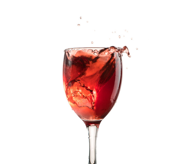 A glass of red wine on a white or black background with splashes. - Foto, Bild