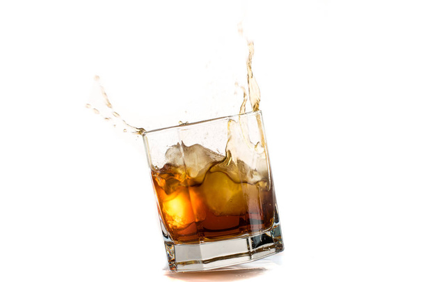 Fallen and falling whiskey glass with ice and splashes - Foto, immagini