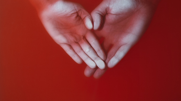 ręce kochającej pary tłoczonej z palmami do szklanki w czerwonej wodzie, ręce mężczyzny i kobiety w kształcie serca, miłości i uczuć koncepcji, tajemniczej sztuki - Zdjęcie, obraz