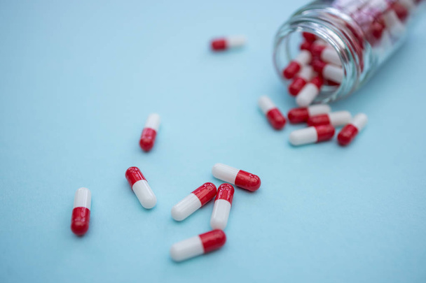 Drugs pills capsules on blue color background - Fotoğraf, Görsel