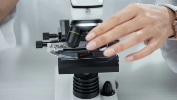 частковий погляд вченого, що кладе зразок із кров'ю у мікроскоп
 - Кадри, відео
