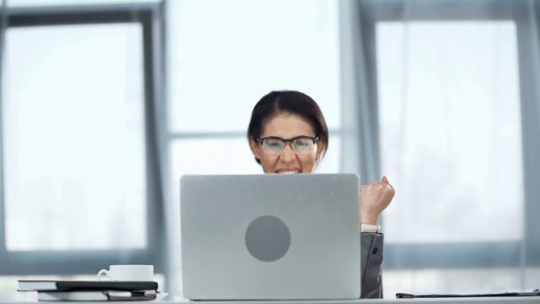 femme d'affaires afro-américaine dans des lunettes à l'aide d'un ordinateur portable et montrant un geste oui
 - Séquence, vidéo