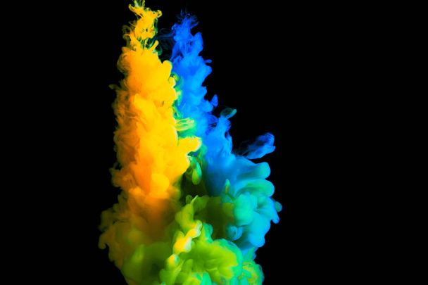 paint stream in water, colored cloud, abstract background, process of mixing multicolored dye on a black background - Zdjęcie, obraz
