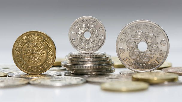 eine Münze mit zehn, einer und fünf Kronen, die auf einem Haufen anderer dänischer Münzen im Panoramaformat steht. die Krone ist die offizielle Währung von Dänemark, Grönland und den Färöern, - Foto, Bild