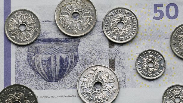 Una banconota da cinquanta corone con una selezione di monete danesi miste. La corona è la valuta ufficiale della Danimarca, della Groenlandia e delle Isole Faroe, introdotta il 1 gennaio 1875.
. - Foto, immagini