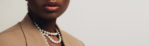 vue recadrée de femme afro-américaine en veste beige et collier isolé sur gris
 - Photo, image