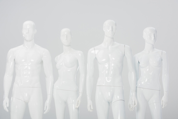 white plastic dummies in row isolated on grey  - 写真・画像