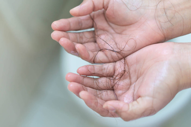Nahaufnahme Haarausfall an Frauenhand im Badezimmer - Foto, Bild