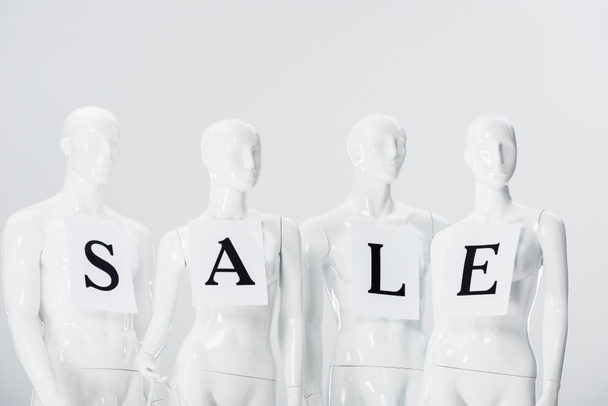 papers with sale lettering on white mannequins isolated on grey - Фото, изображение