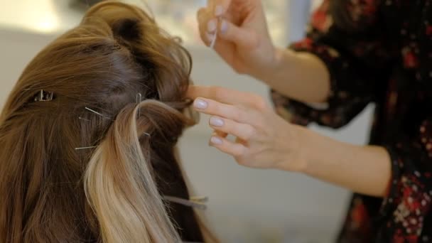 Egy nő fodrász csinál egy terjedelmes frizura, hogy az ügyfél segítségével a haj ironer, préseléséhez haj. Professzionális fodrász a munkahelyen. Master hogy frizura egy lány a szépségszalonban lassított - Felvétel, videó