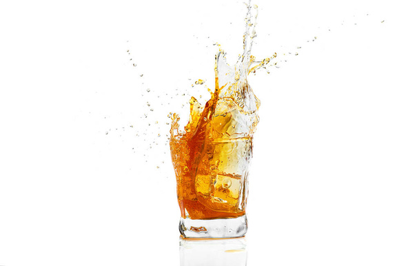 Whiskey with splash on white background, brandy in a glass - Fotografie, Obrázek