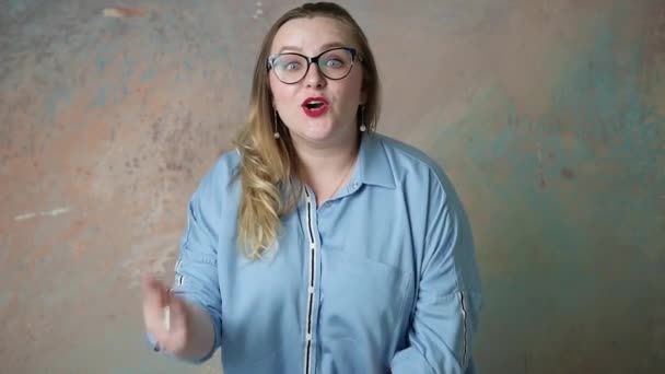 Portrait of attractive plus size in glasses woman having emotions positive, joy and surprise isolated over colored background. Concept of emotions. - Filmati, video