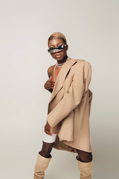 gri izole bej ceket poz çıplak afro-amerikan kız - Fotoğraf, Görsel
