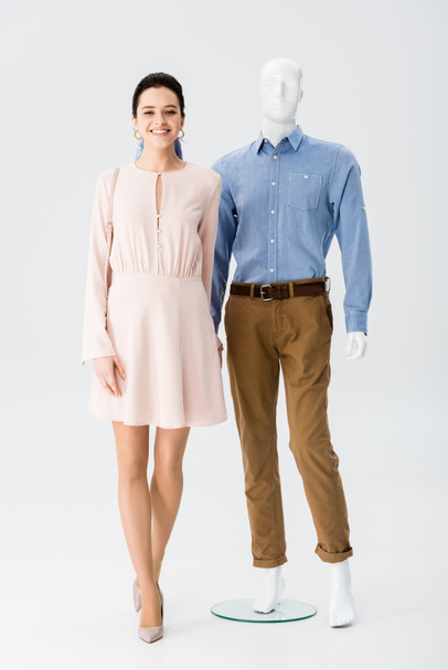 beautiful smiling girl holding hands with mannequin on grey - Photo, Image