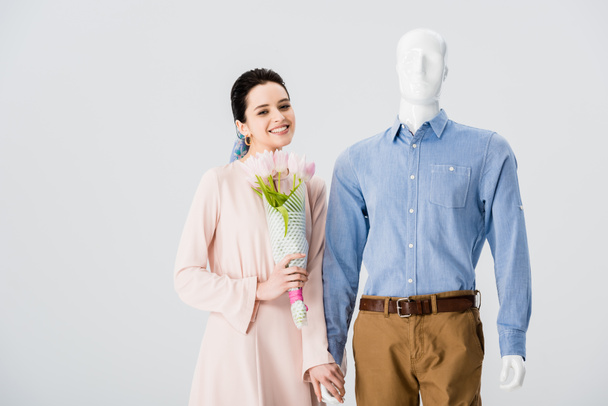 beautiful smiling girl with mannequin and flower bouquet isolated on grey - Fotografie, Obrázek