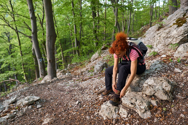 Woman hiker tying laces on her boots - Photo, image