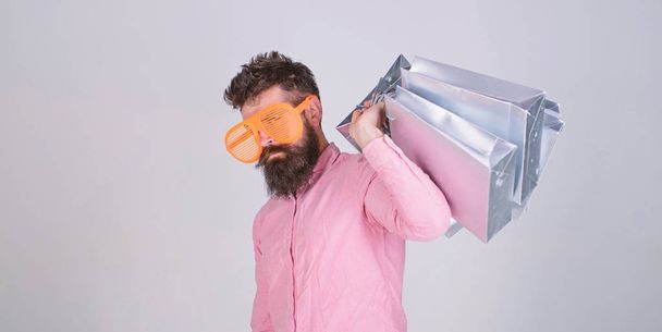 Man bearded hipster wear sunglasses hold bunch shopping bags. Shopping on black friday. Happy shopping with bunch paper bags. Shopping addicted consumer. How to get ready for your next vacation - Valokuva, kuva