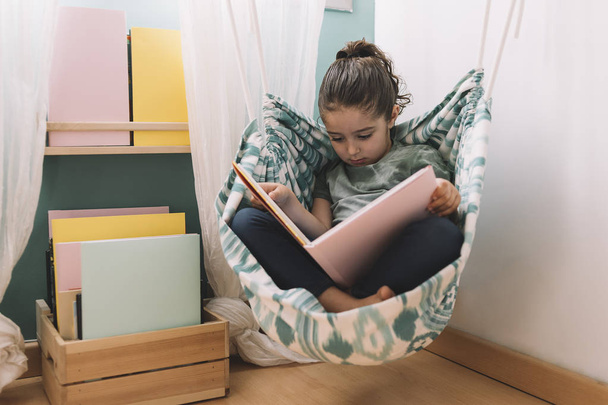 relaxed little girl reading at home - Foto, imagen