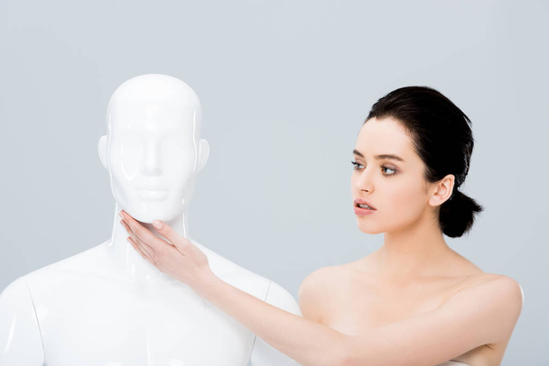 beautiful naked young woman touching mannequin isolated on grey - Fotó, kép