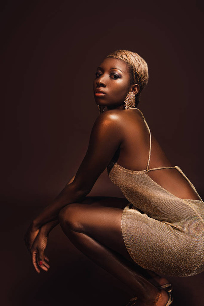 young glamorous african american woman with short hair isolated on brown - Фото, зображення