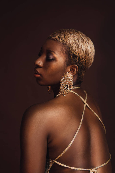 beautiful african american model with short hair isolated on brown - Foto, immagini