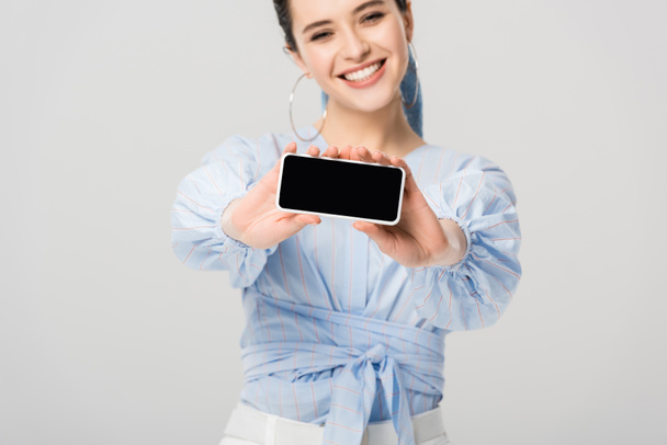 beautiful stylish girl showing smartphone with blank screen isolated on grey - Photo, image